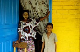 Blue-door;-Boy;-Comoros-Archipelago;-France;-Indian-Ocean;-Kaleidos;-Kaleidos-images;-La-parole-à-limage;-Laurent-Abad;-Mayotte;-Msindzano;-Portrait;-Stories-Pictures;-Woman;-Yellow-wall